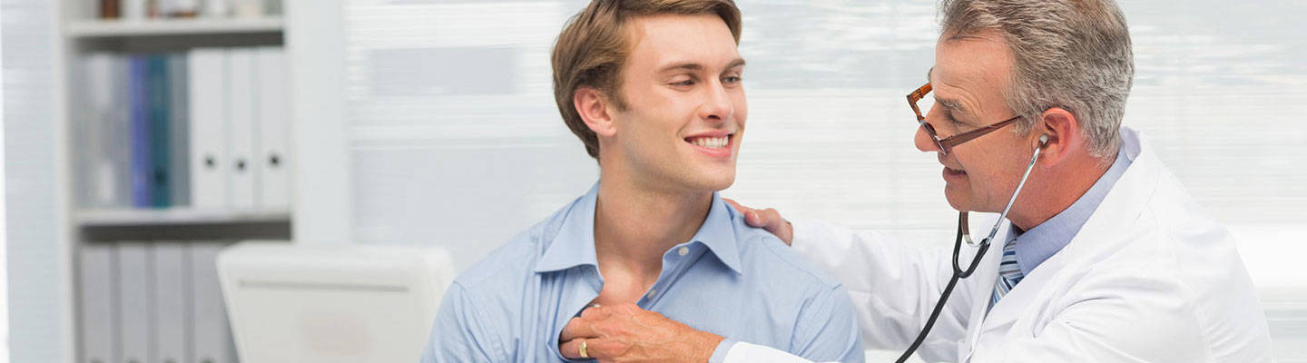 Male doctor examining patient with stethoscope