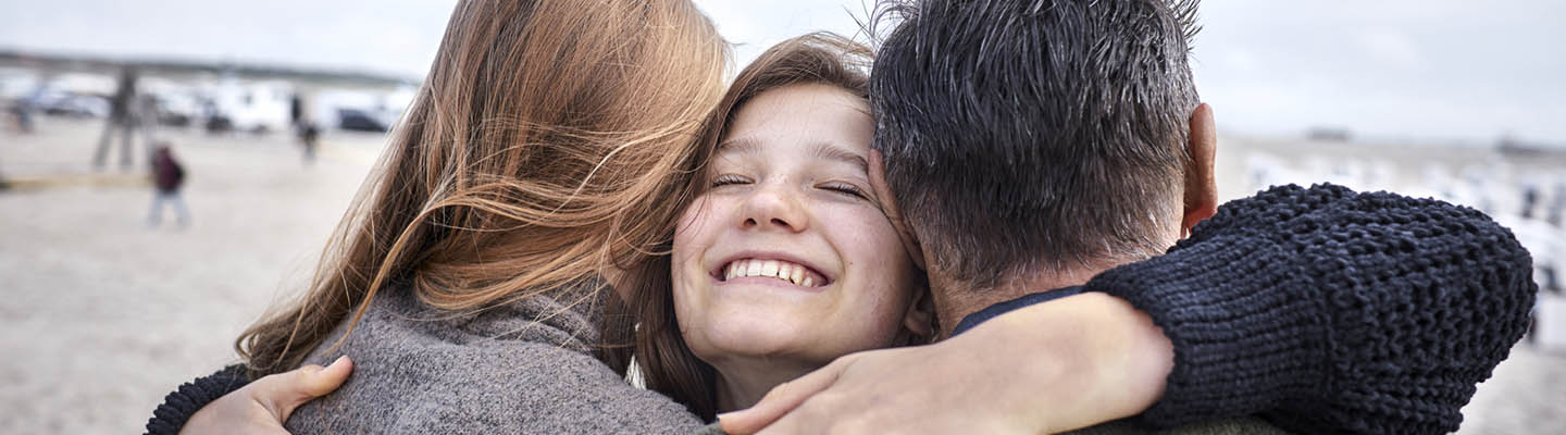 happy girl hugging mother and father